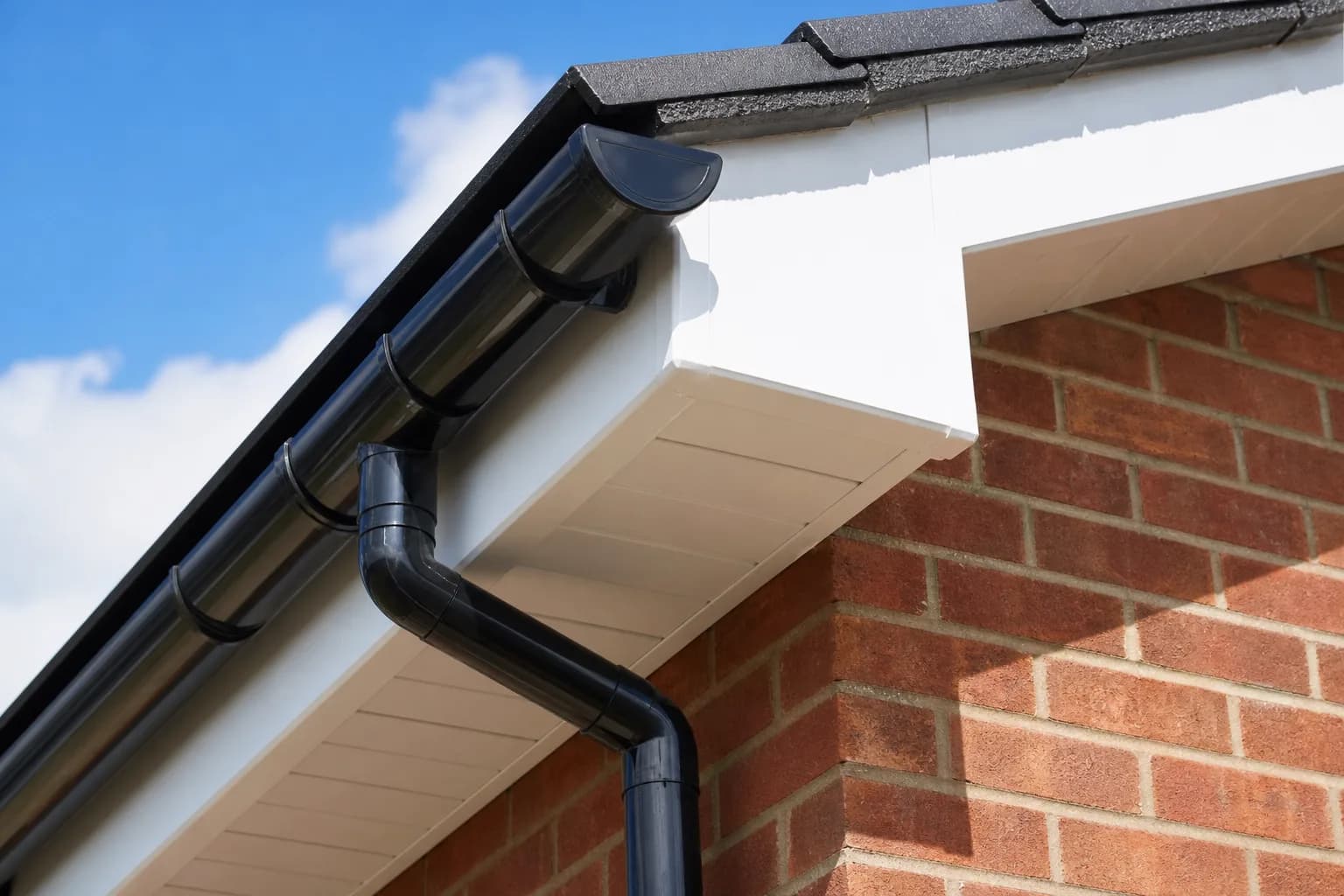 New black UPVC guttering and white fascia along the edge of a house roof