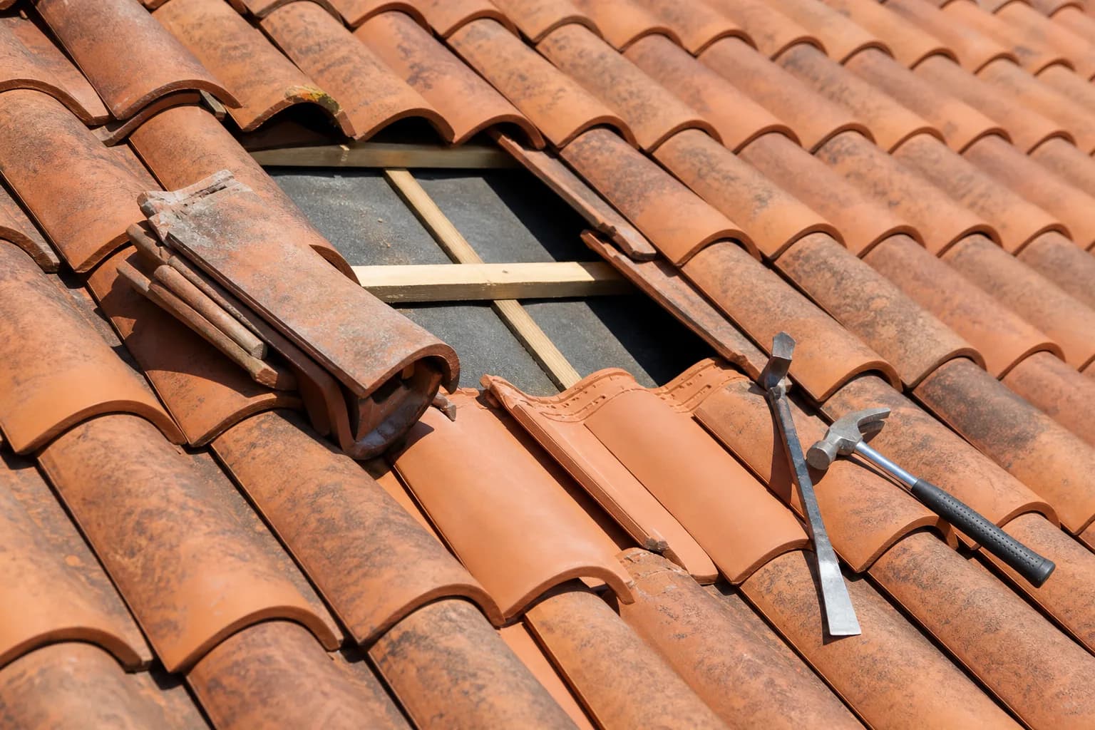 Close-up of pitched roof tiles being repaired on a Kent home